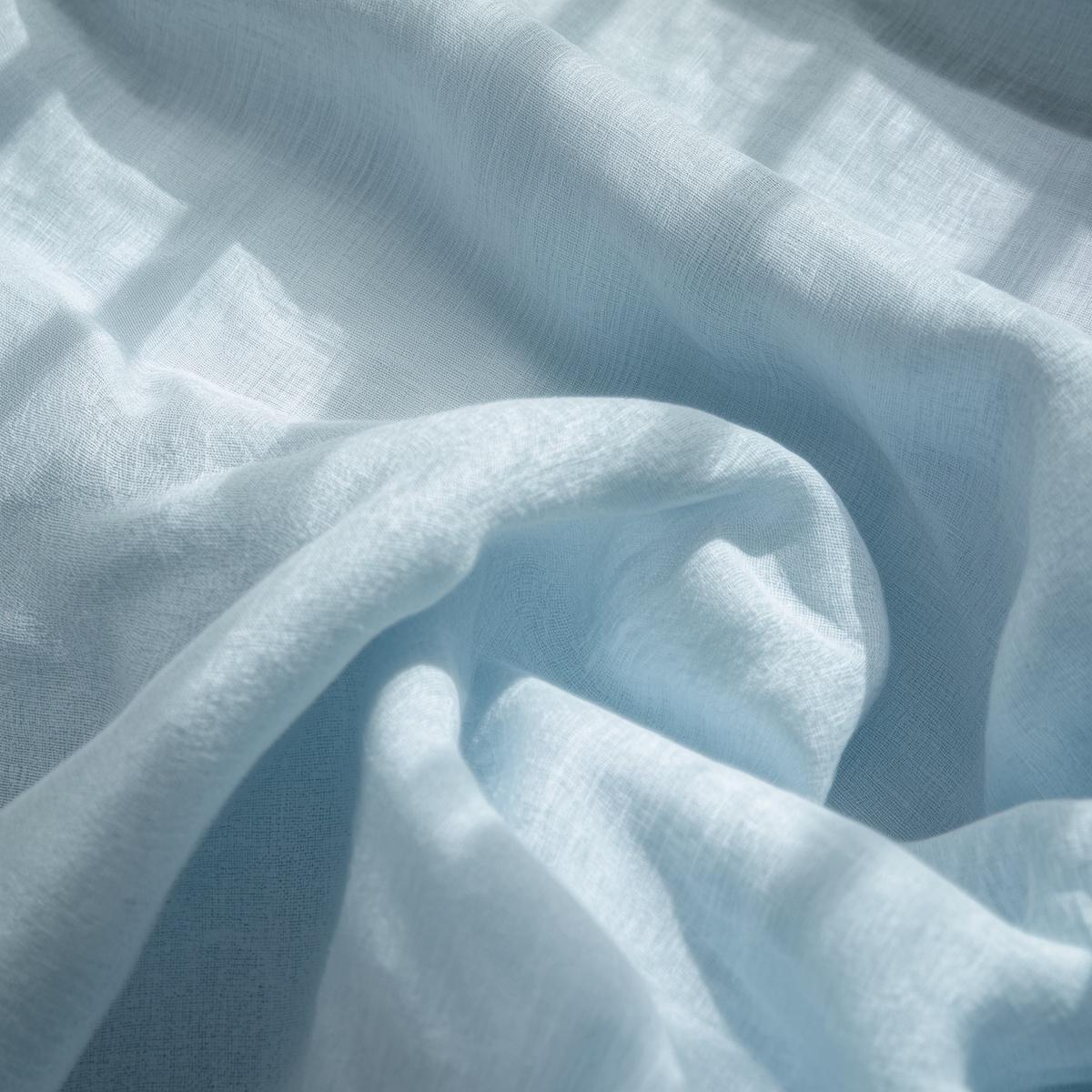 draped linen chambray fabric, baby pastel blue linen cloth with subtle heathered weave, lightweight breathable textile, natural sunlight across folds, refined textile photography