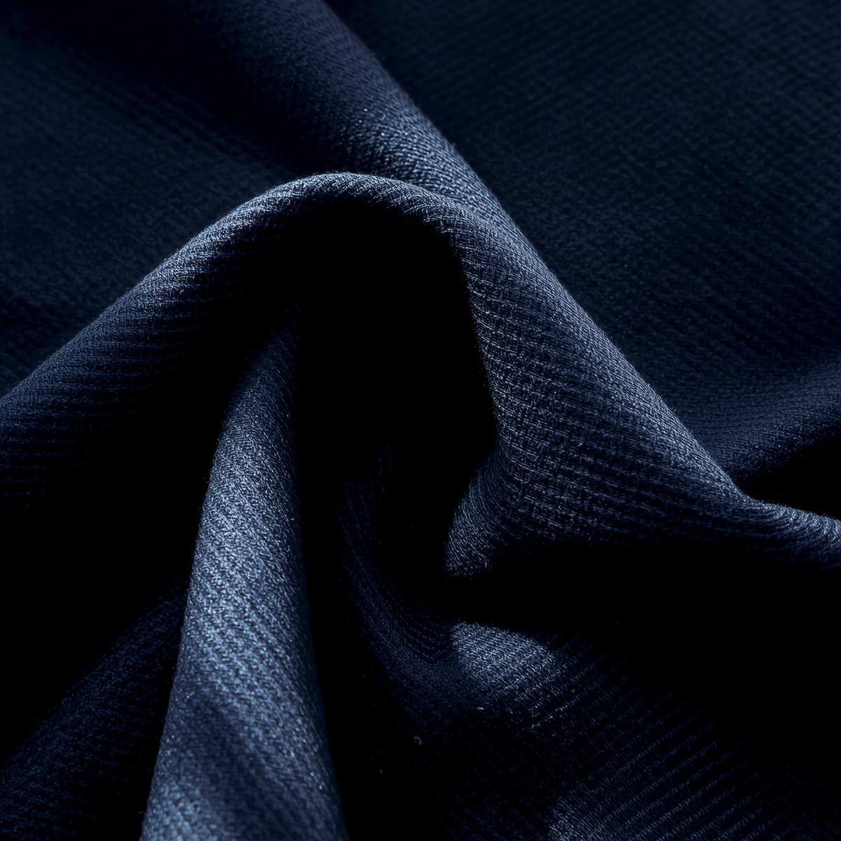 draped wool gabardine fabric, navy wool cloth with subtle diagonal weave pattern, smooth structured folds, bright natural sunlight highlighting texture, refined textile photography
