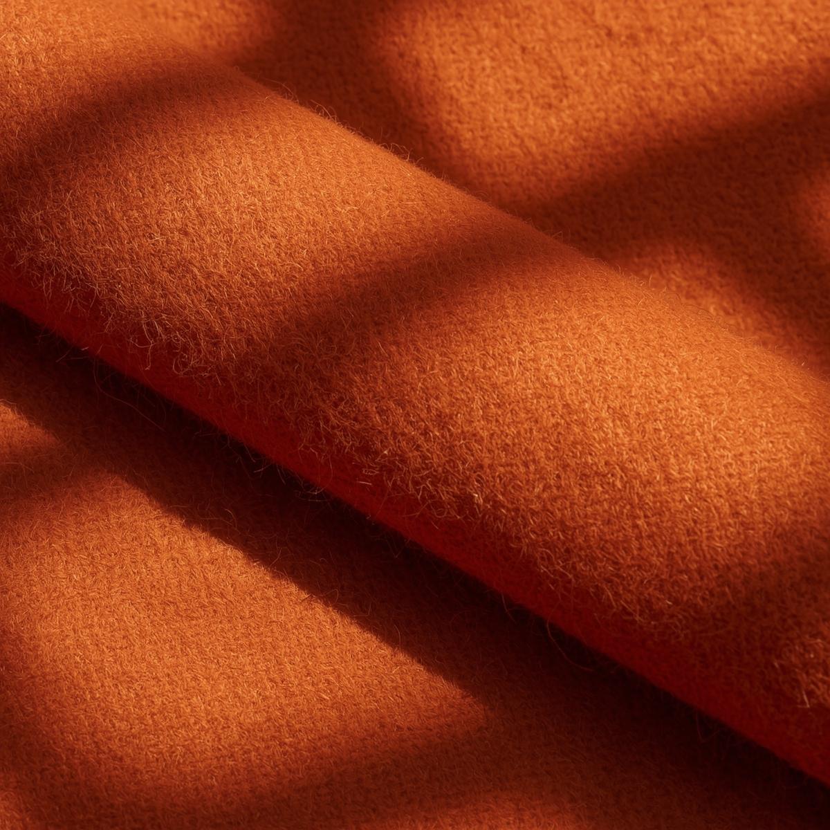 rolled wool melton fabric bolt, terracotta colored wool cloth with dense smooth texture, thick structured textile, warm natural sunlight, artisan textile photography